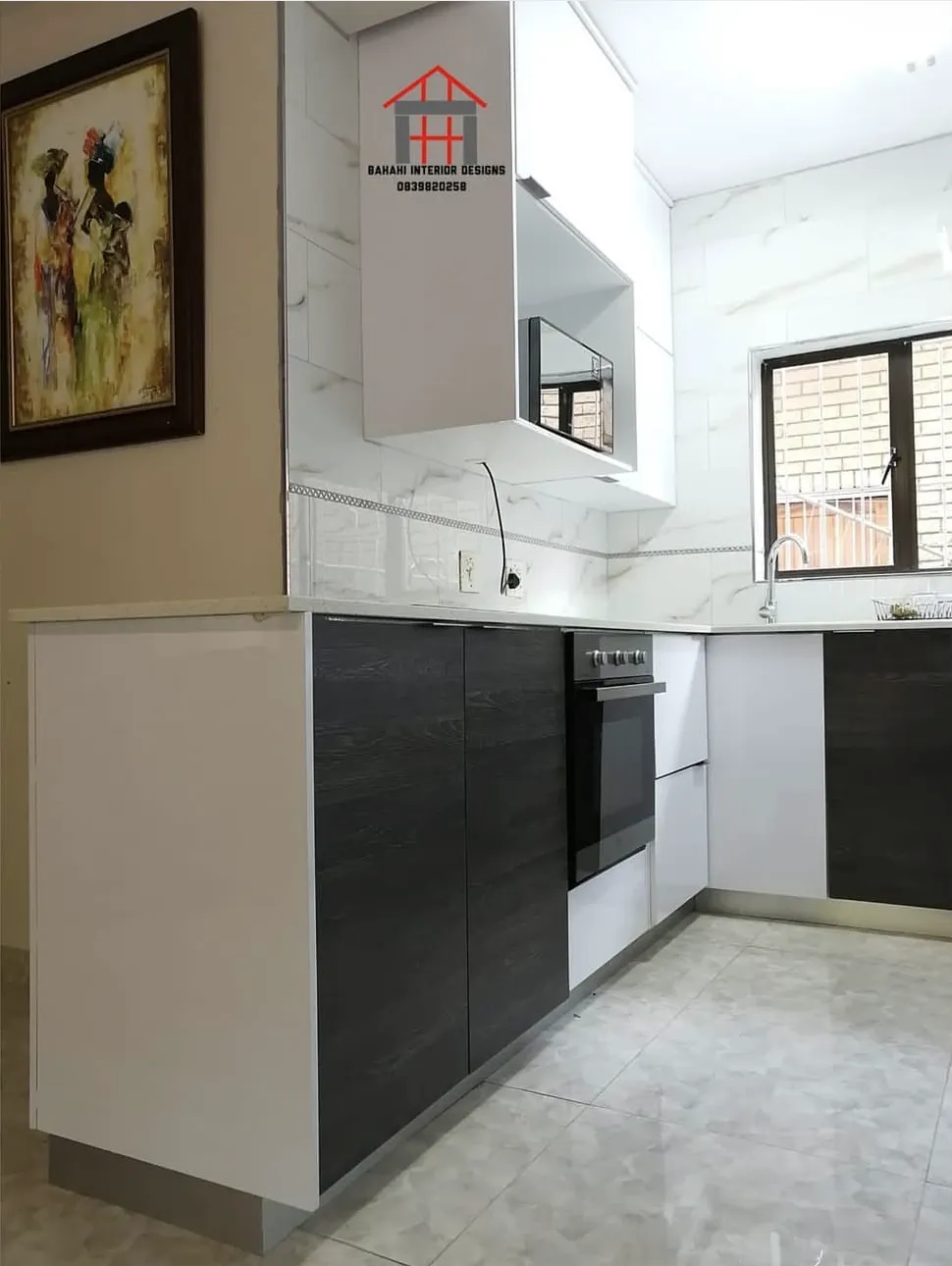 Dark oak-grain base units and a built-in oven under white gloss wall cupboards.
