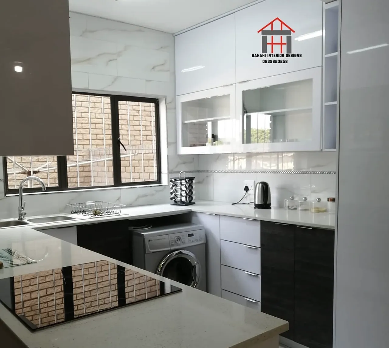 White gloss wall units with glass fronts over a quartz top and marble-look wall tiles.