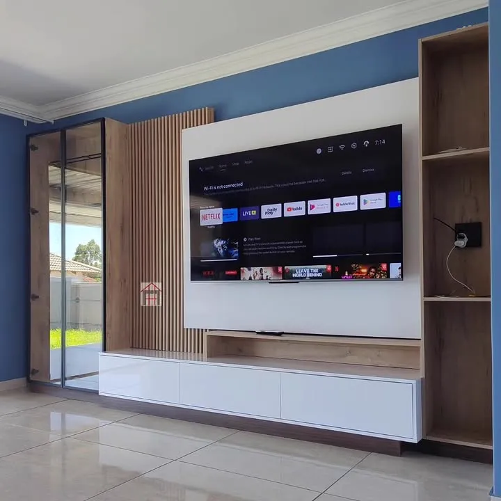 A white gloss TV unit with a floating panel and open oak-grain shelving at one end.
